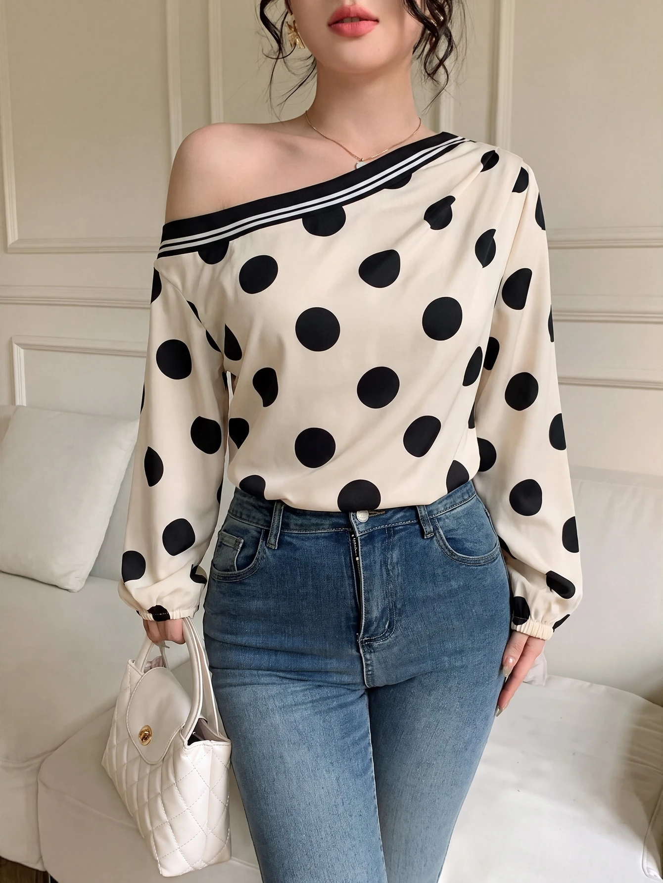 Blusa con estampado de lunares y cuello asimétrico